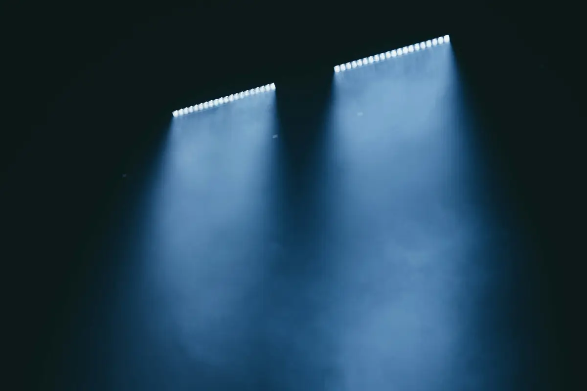Two stage lights cut pale beams through the dark.